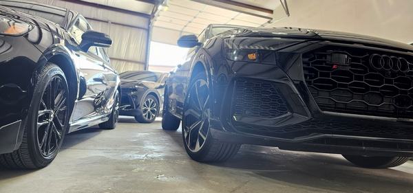 Low angle view of glossy black vehicles inside the shop