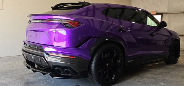Rear three-quarter view of a purple SUV with a carbon fiber rear diffuser