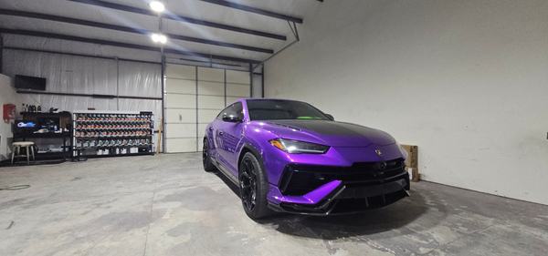 Purple performance SUV with a carbon fiber body kit parked in the ClearFlow shop, paint shelves in the background